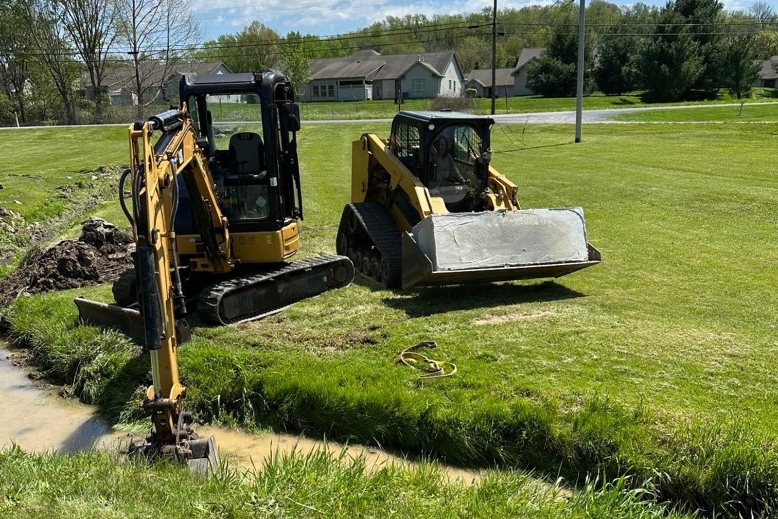 Exterior French drain excavation with mini excavator and track loader in Pittsburgh