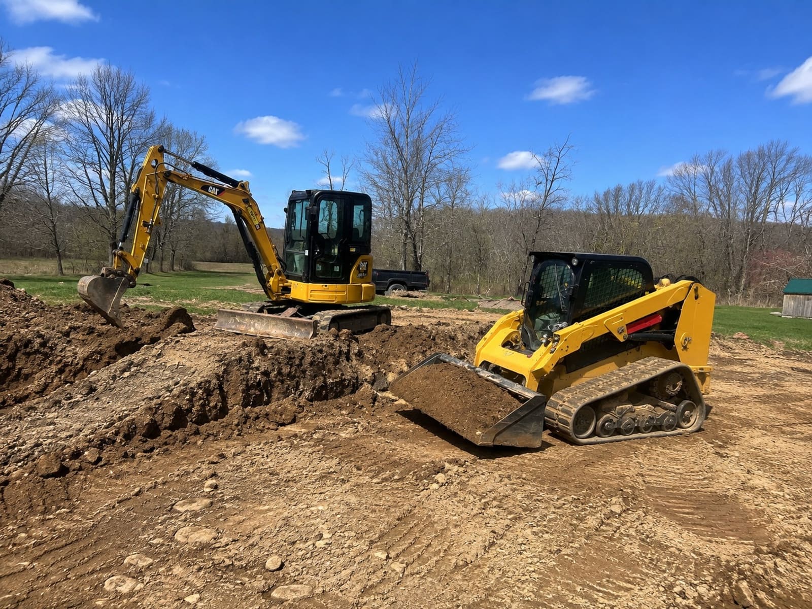 Mini excavator and track loader cutting into a Pittsburgh site during excavation