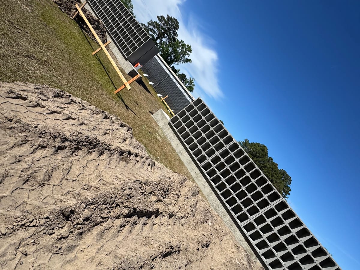 Runs of open-grid precast concrete wall units installed on a prepared base